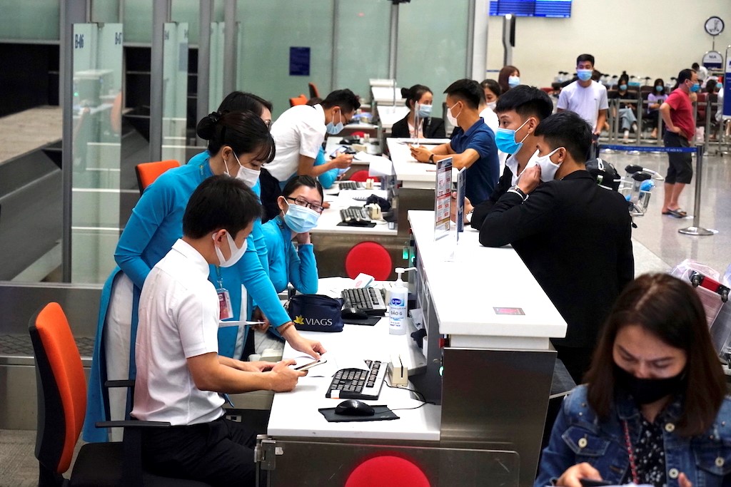Hành khách tuân thủ việc đeo khẩu trang khi làm thủ tục tại sân bay Hành khách tuân thủ việc đeo khẩu trang khi làm thủ tục tại sân bay